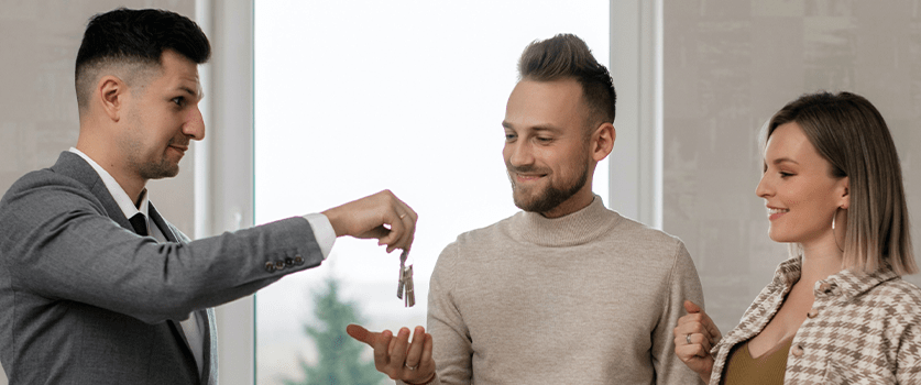 Young couple receiving keys to their new home